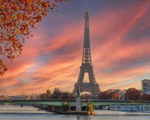 The Eiffel Tower and the river Seine under a pink sunset sky in Paris