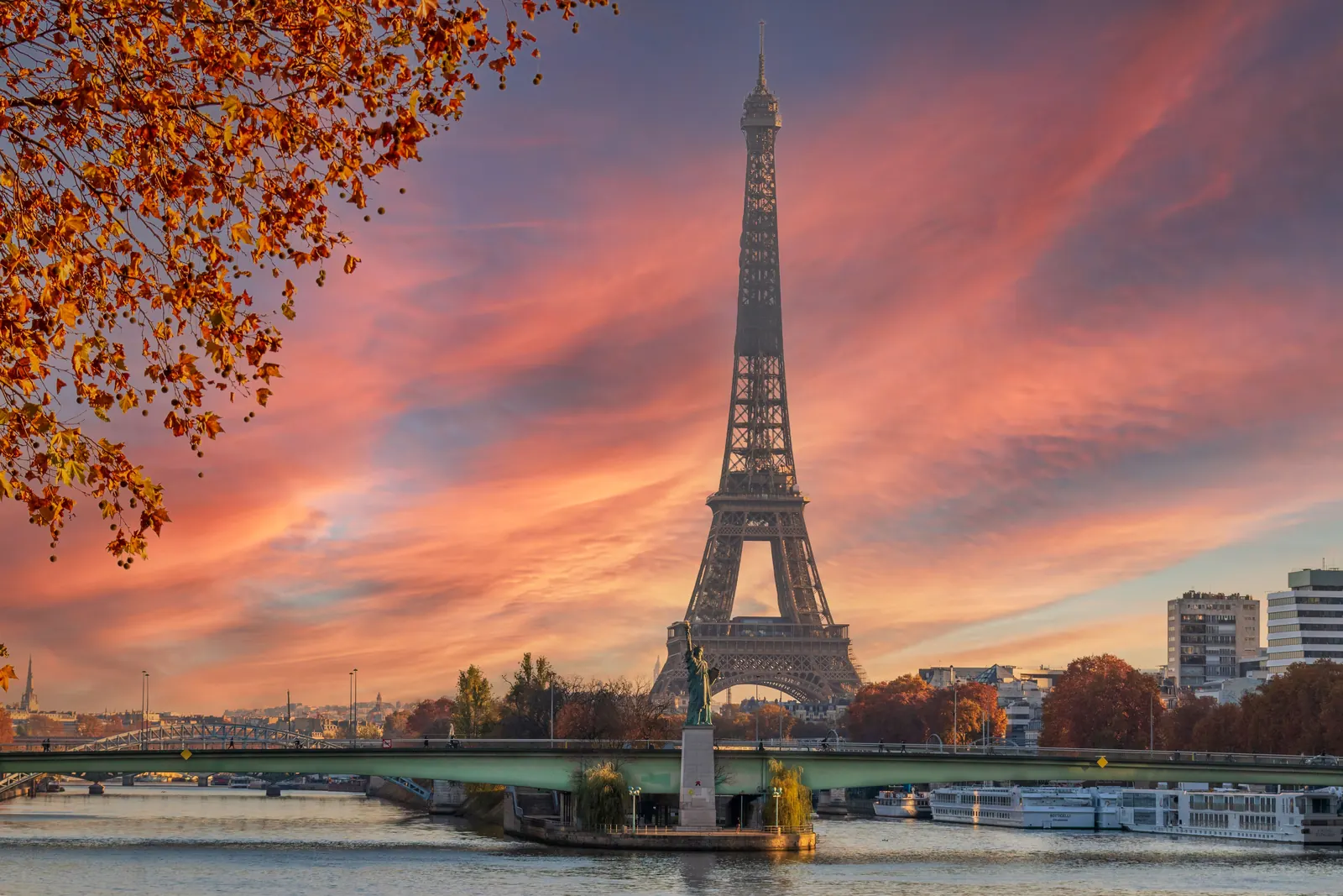 The Eiffel Tower and the river Seine under a pink sunset sky in Paris