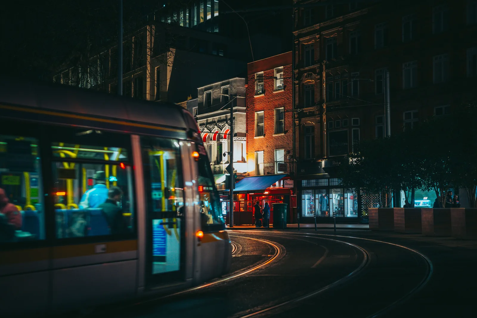 A Luas tram moving through a Dublin street at night