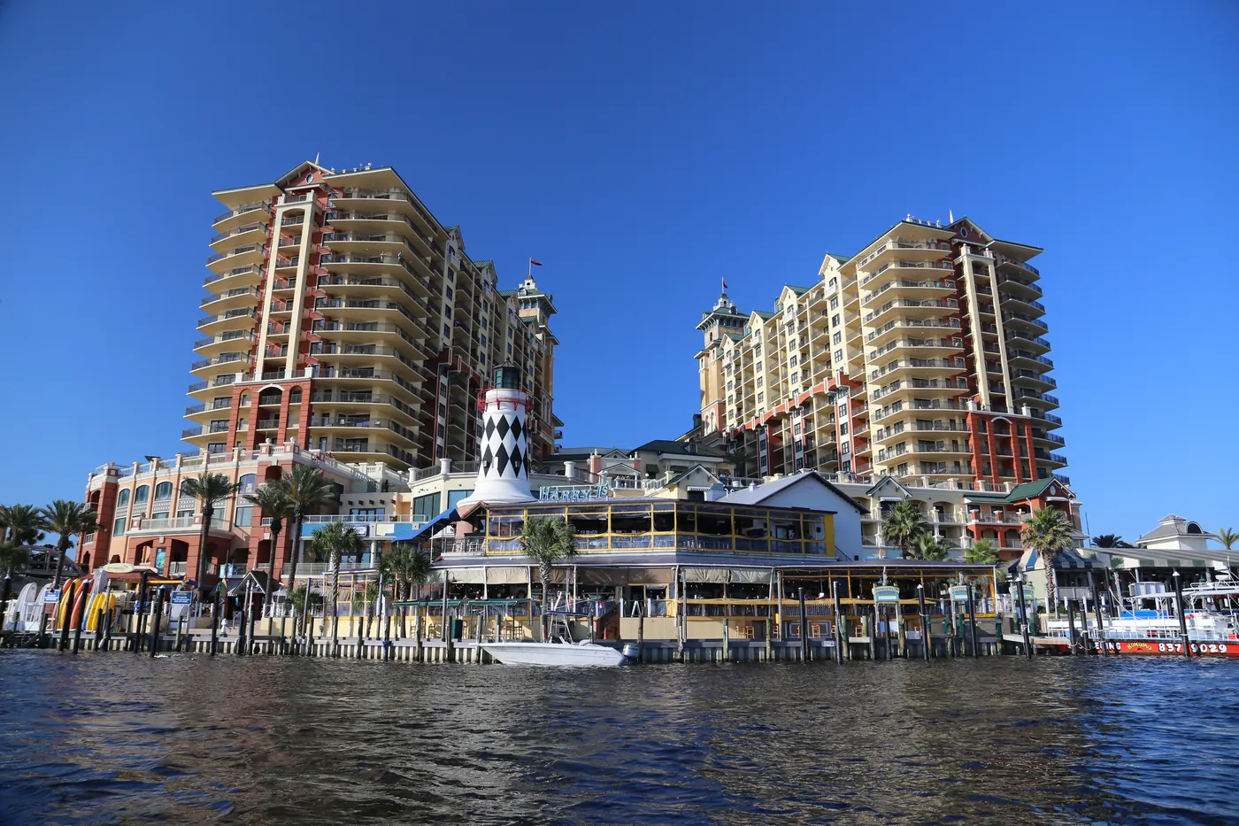 HarborWalk Village and its boardwalk seen from the water in Destin
