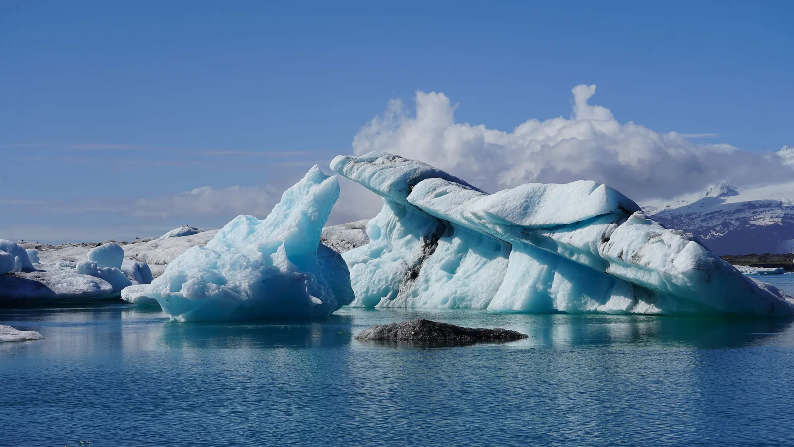 A single blue iceberg floating in the still water of Jokulsarlon lagoon