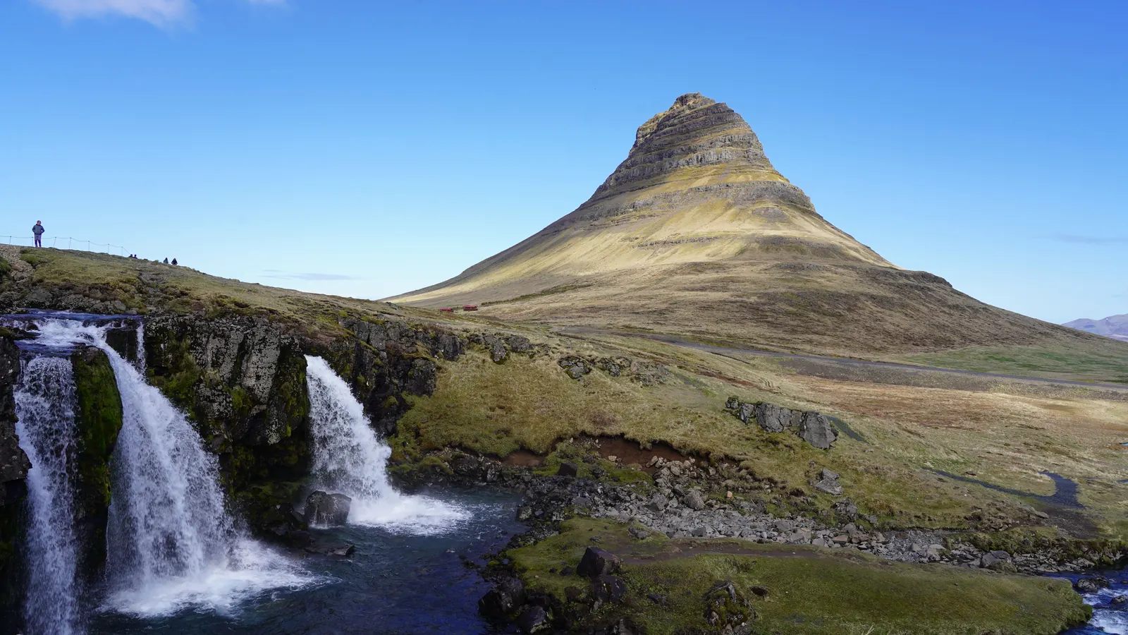 The pointed peak of Kirkjufell with waterfalls in the foreground on the Snaefellsnes peninsula