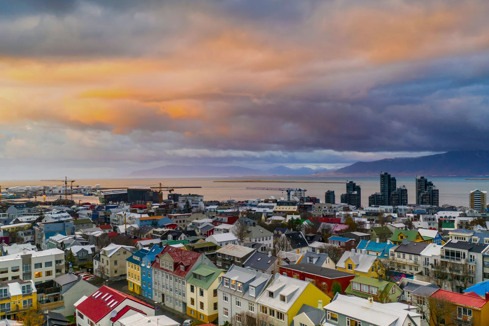 Colourful rooftops of Reykjavik at sunset with the bay and mountains behind