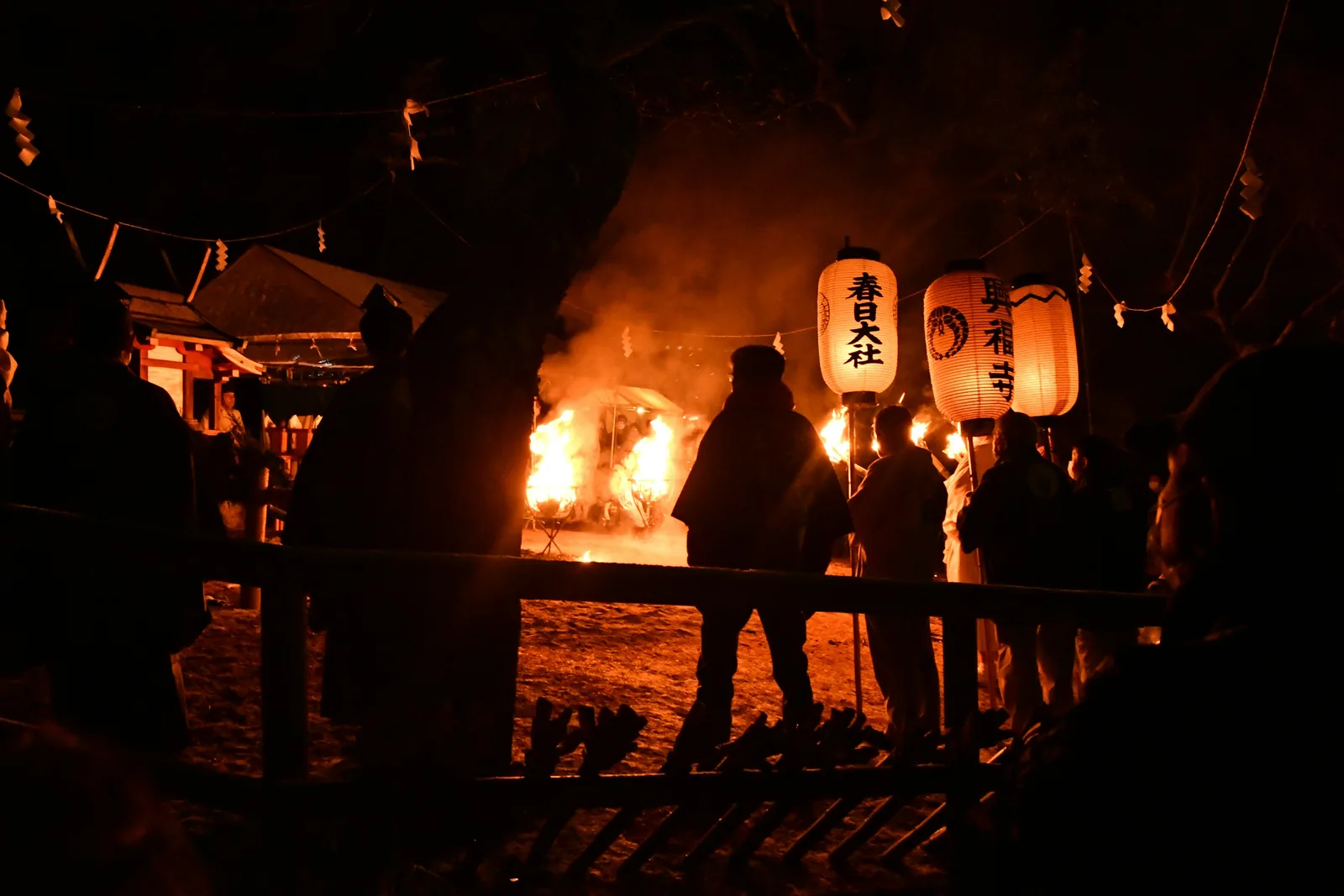 A wooden frame burning at a Japanese fire festival at night