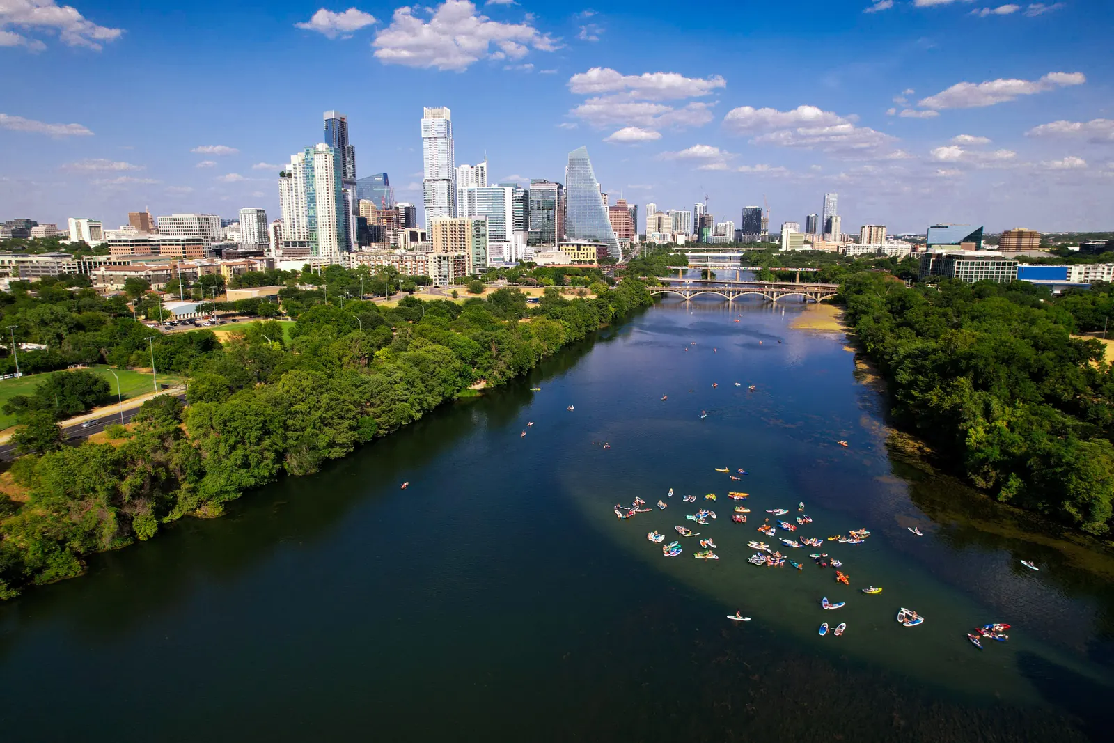 Paddlers on the water below the Austin skyline seen from above