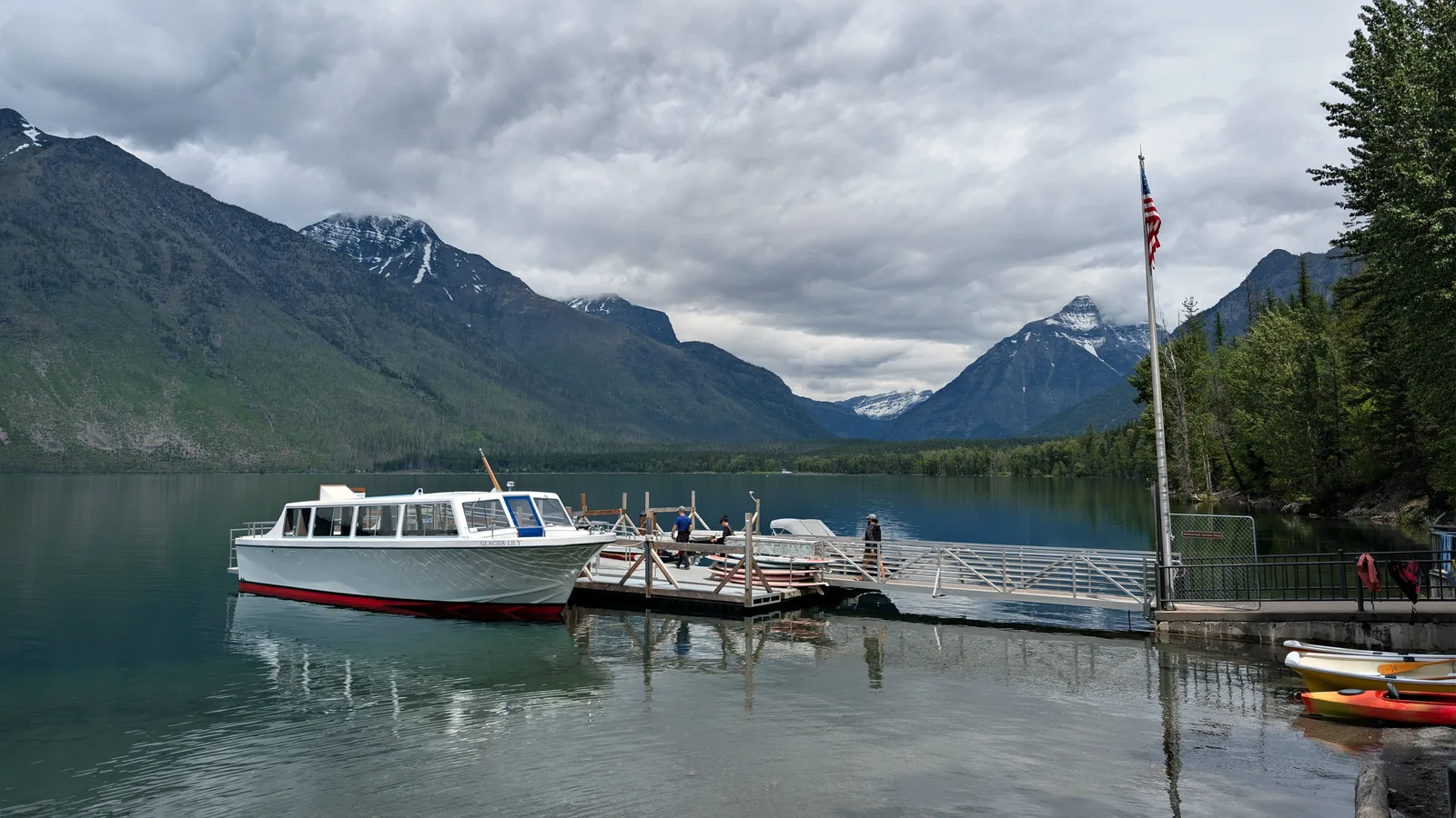 A wooden dock and tour boat on Lake McDonald in Glacier National Park