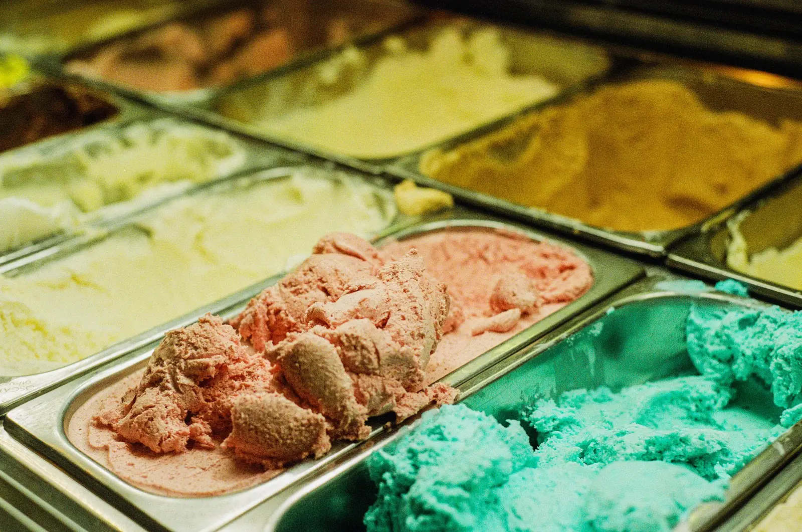 Trays of ice cream in different flavours behind a counter