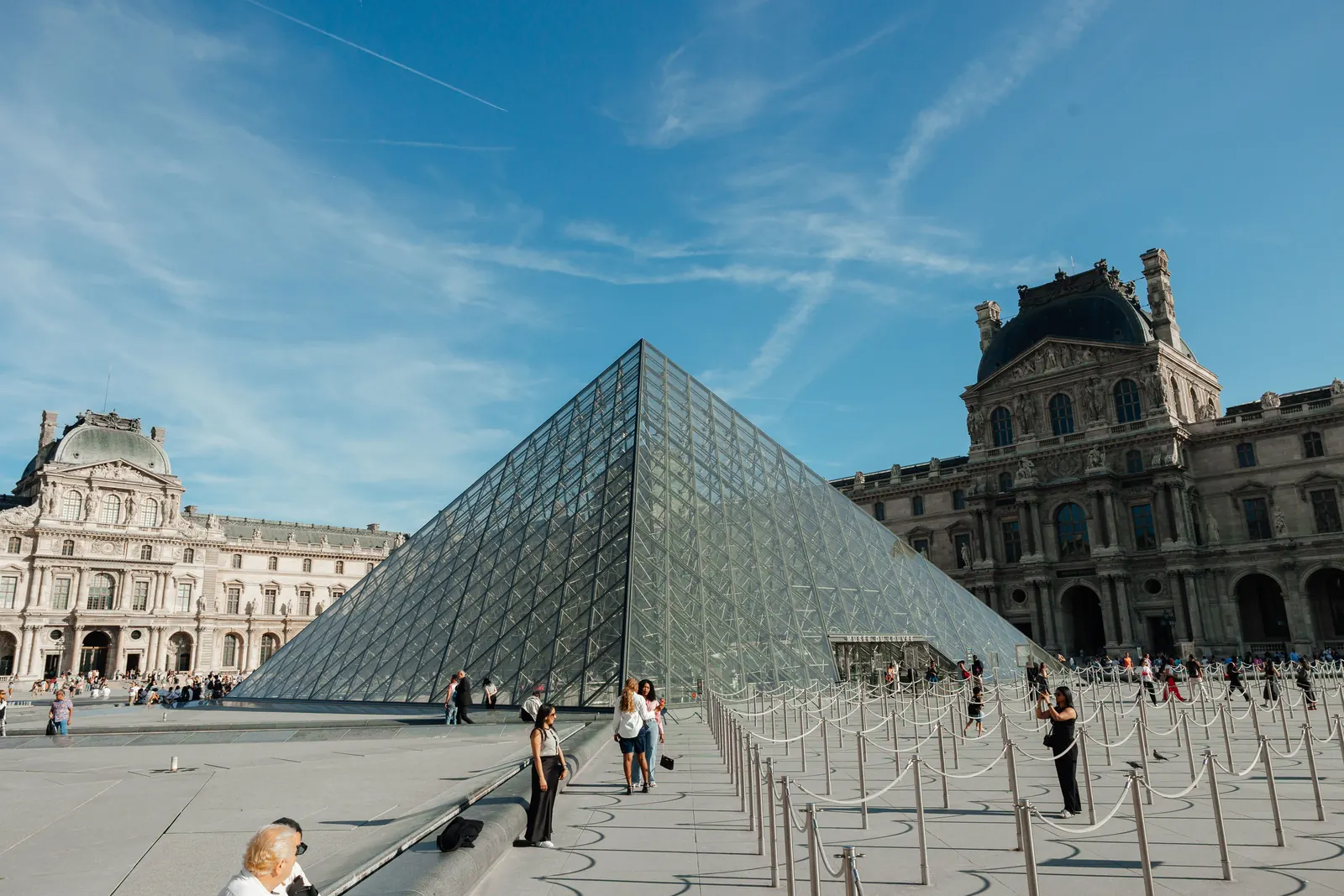 The glass pyramid in the courtyard of the Louvre on a sunny day in Paris