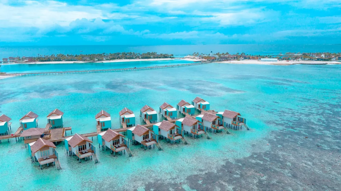 Overwater villas standing over a turquoise lagoon at a tropical resort