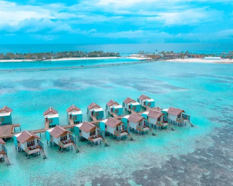 Overwater villas standing over a turquoise lagoon at a tropical resort