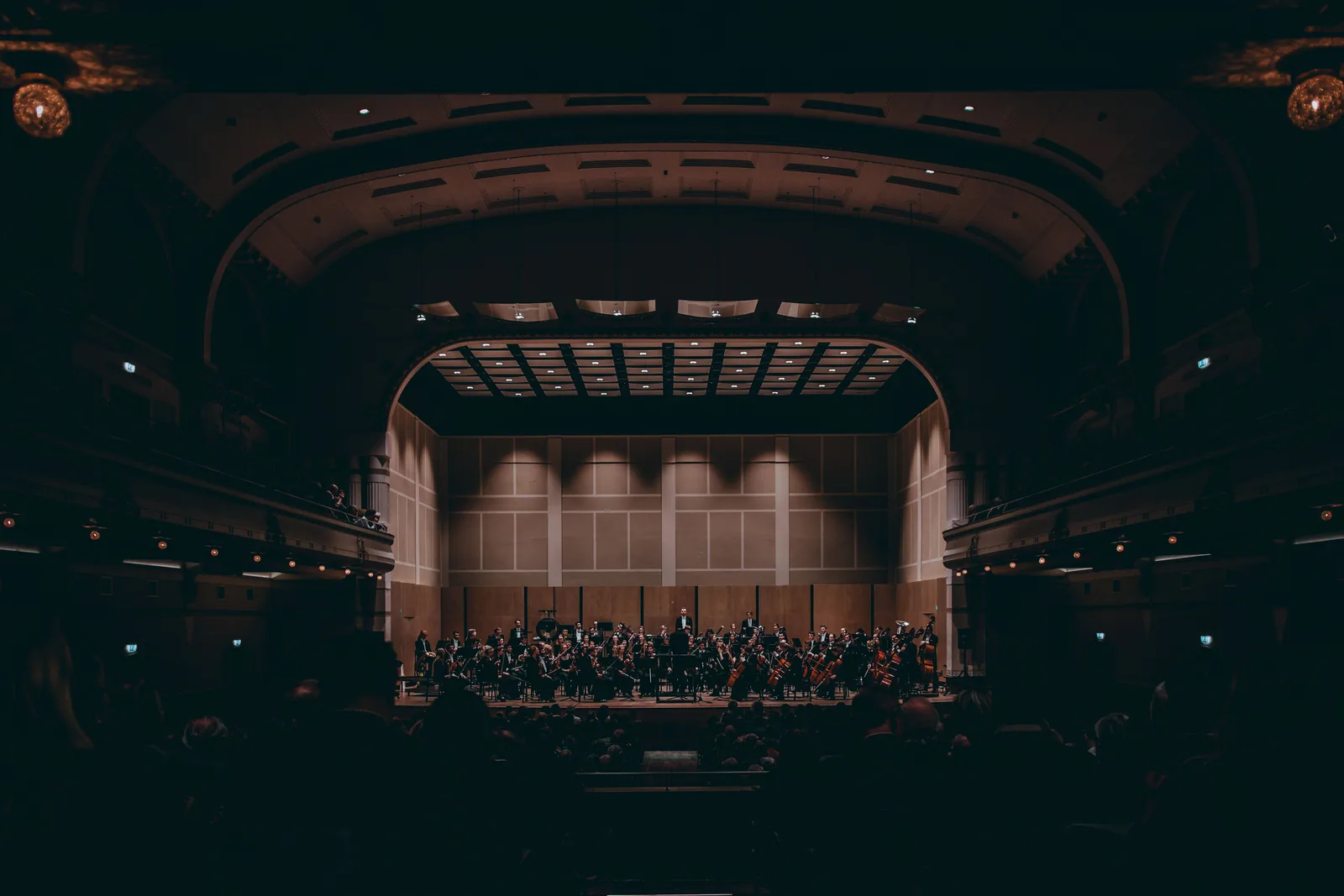An orchestra performing on stage in a concert hall