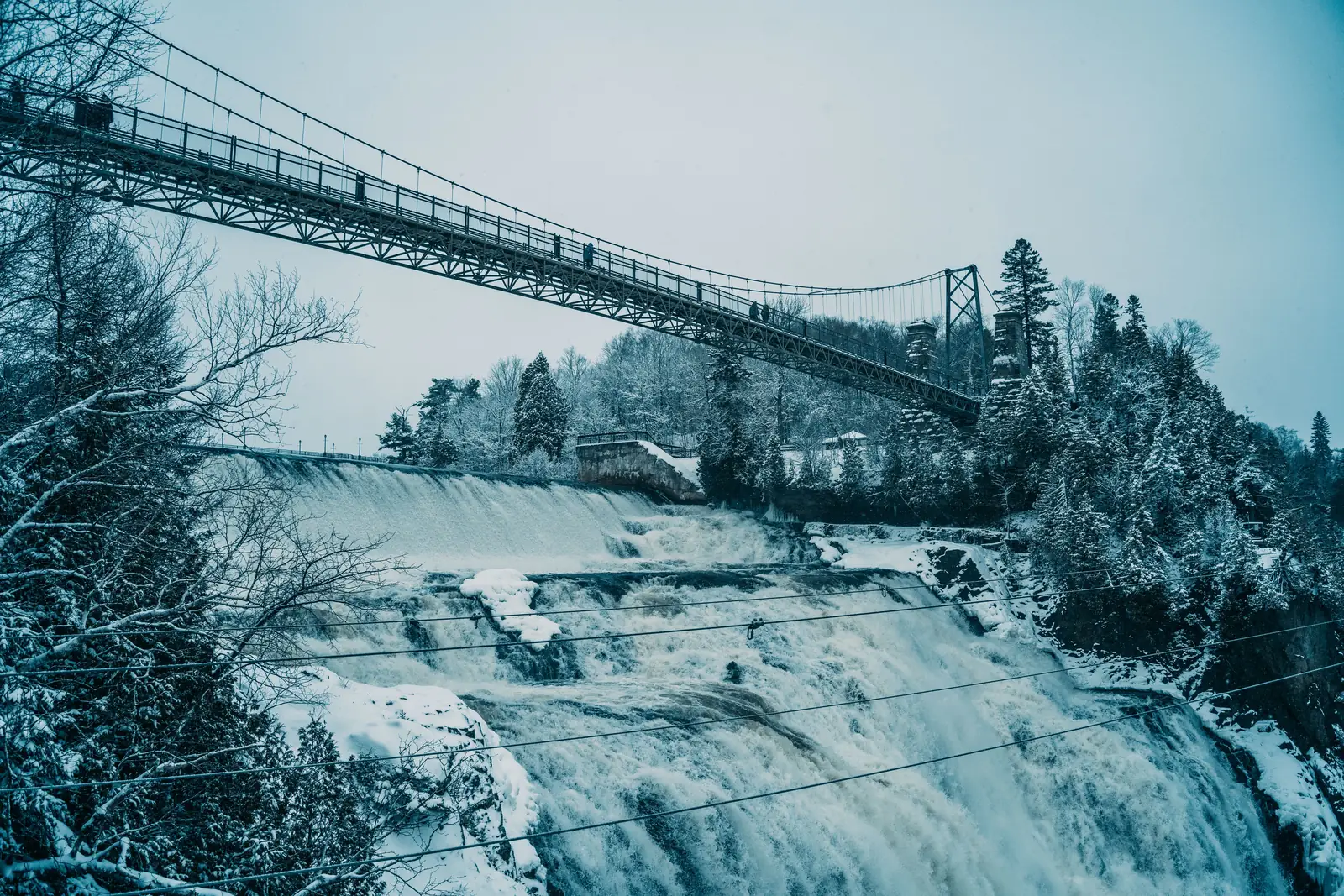 The suspension bridge over Montmorency Falls in winter