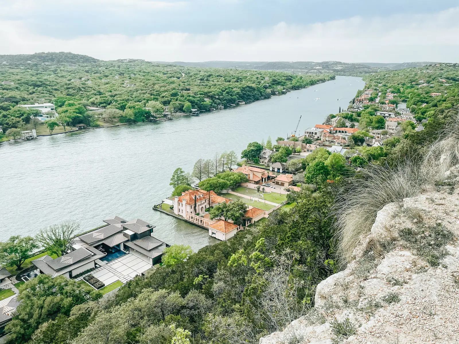 A bend in the river below a limestone bluff with houses along the bank