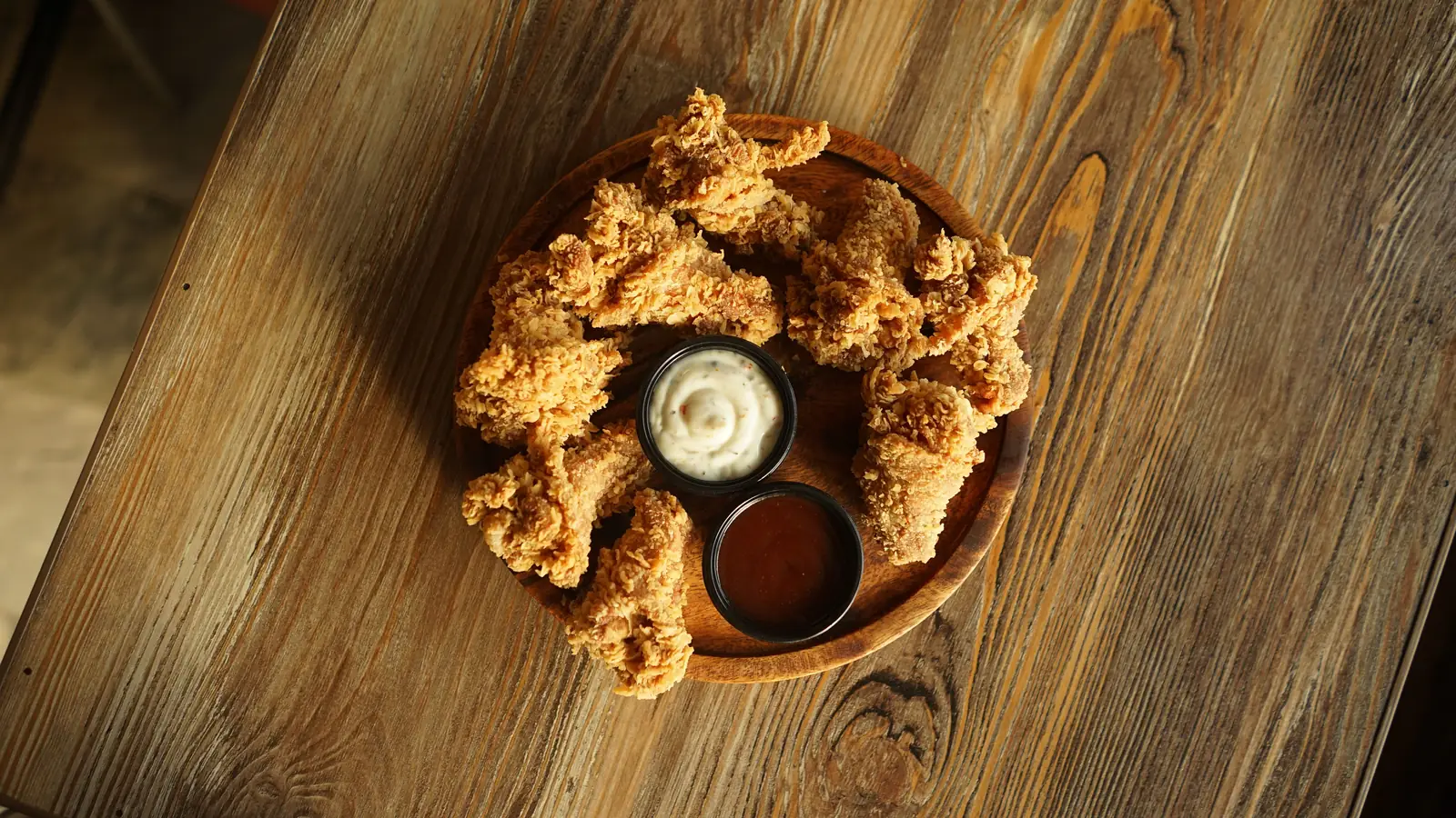 A bowl of crispy southern fried chicken with dips