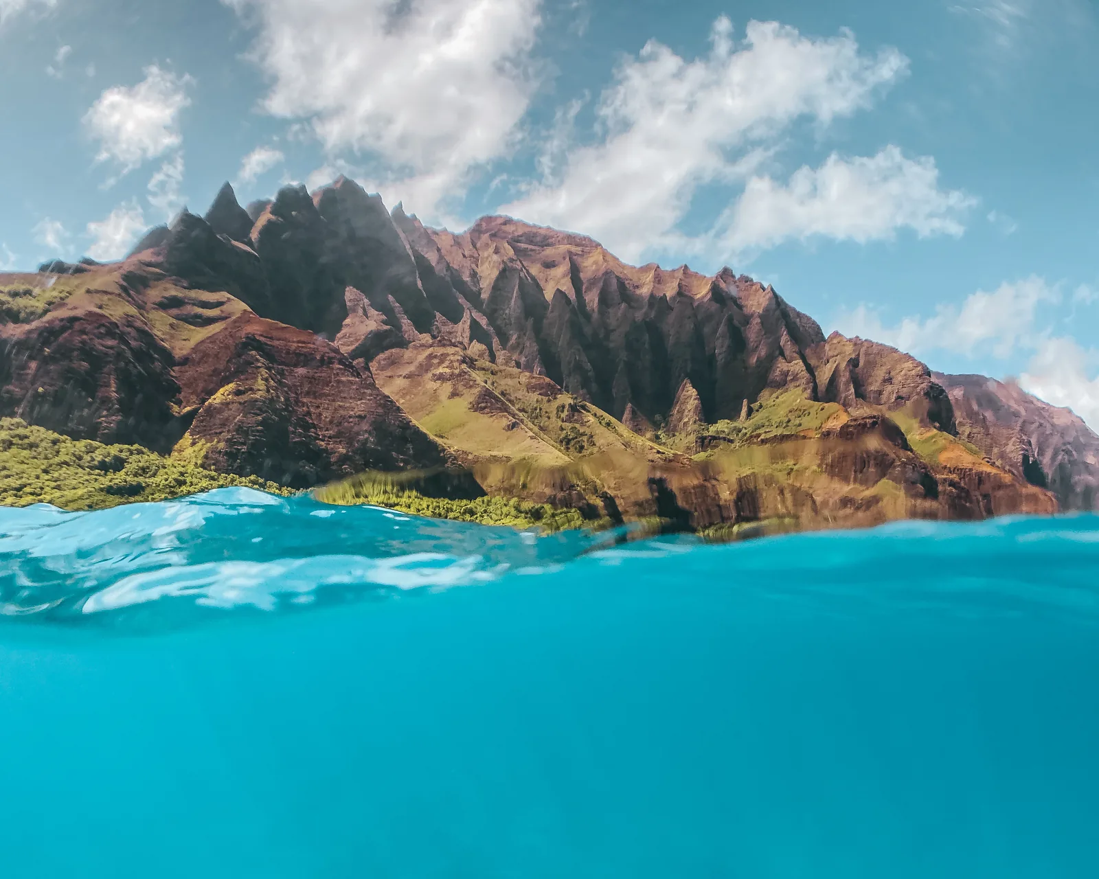 A split view above and below the water in front of the Na Pali cliffs, Kauai
