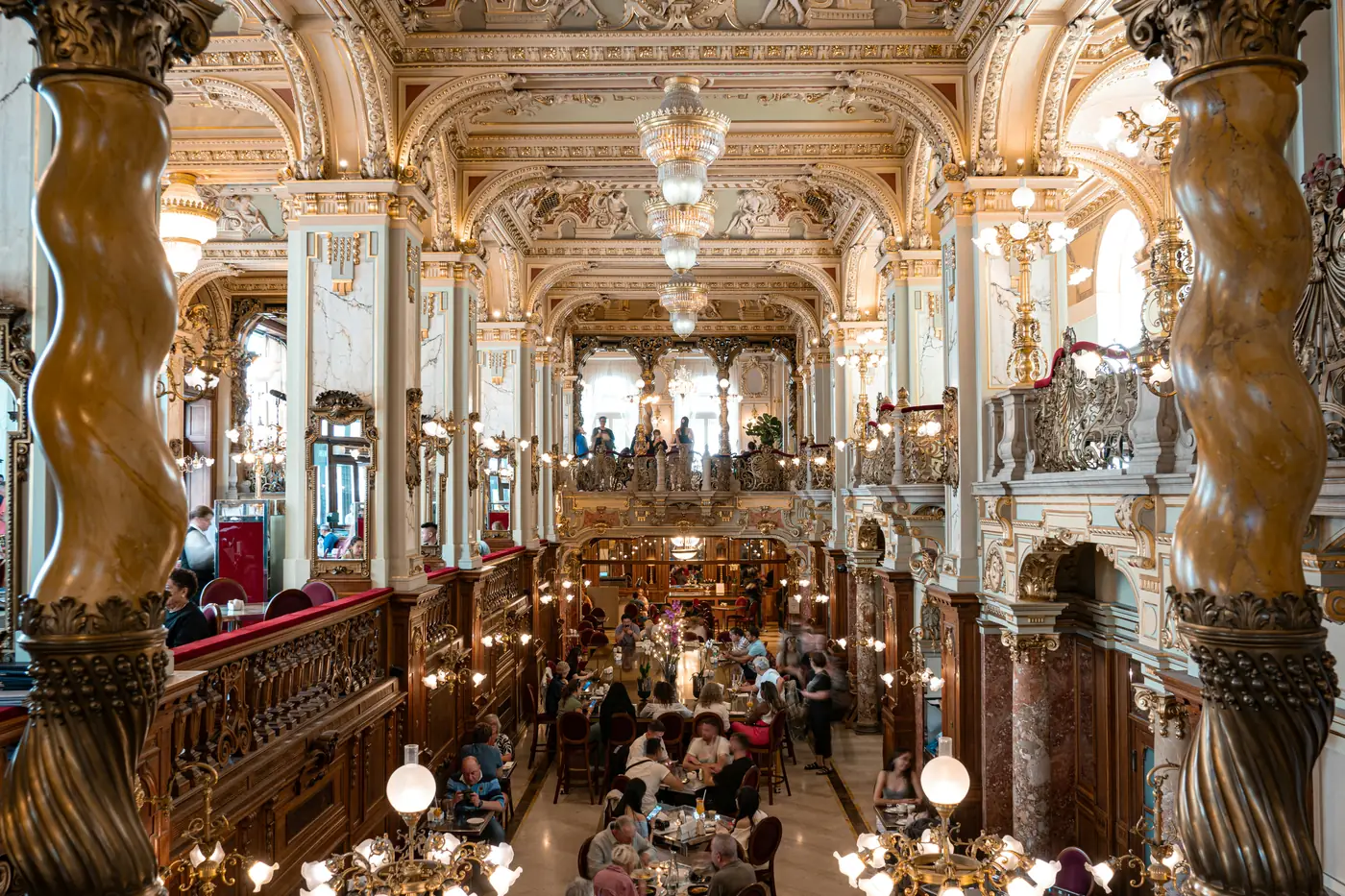 The gilded interior and twisted marble columns of the New York Cafe in Budapest