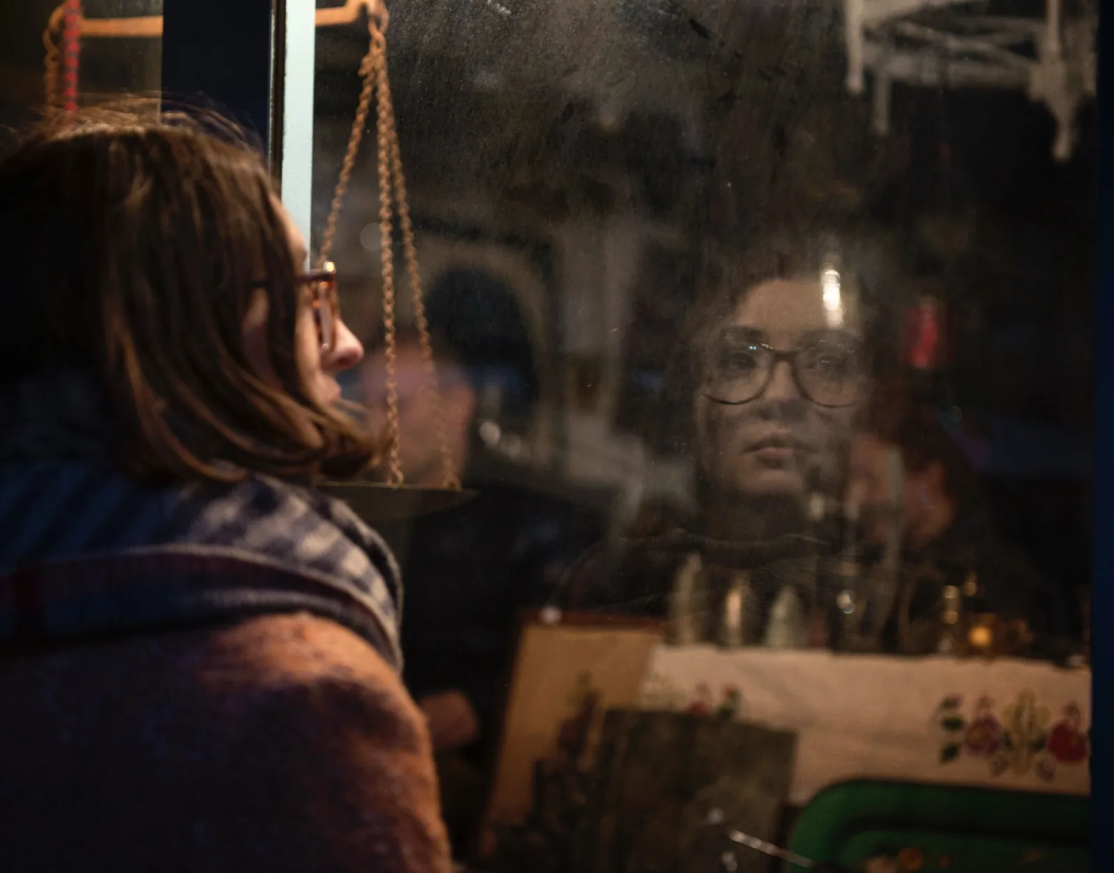 A woman stopping to look at a decorated shop window in winter