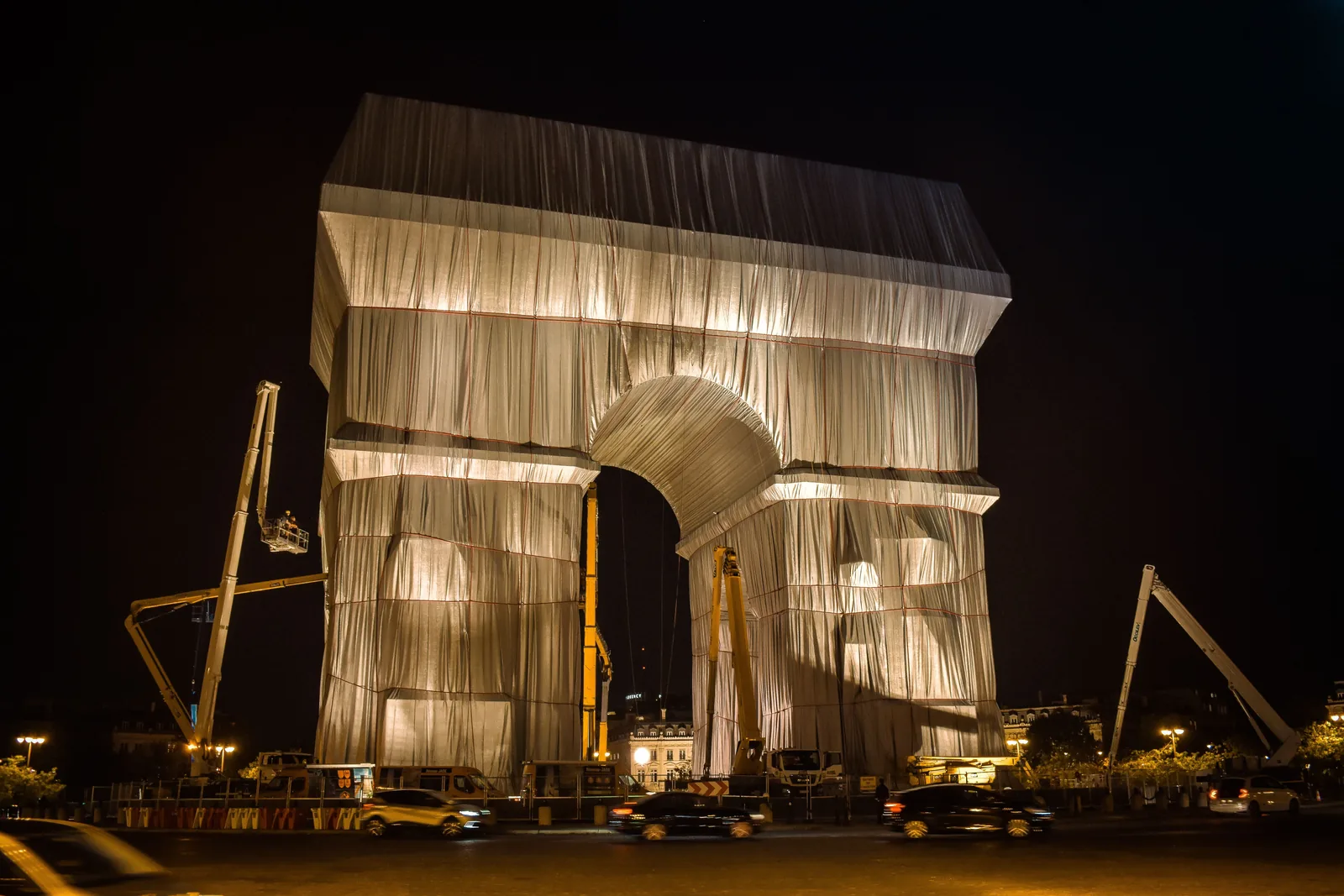 The Arc de Triomphe wrapped in silver fabric and lit up at night