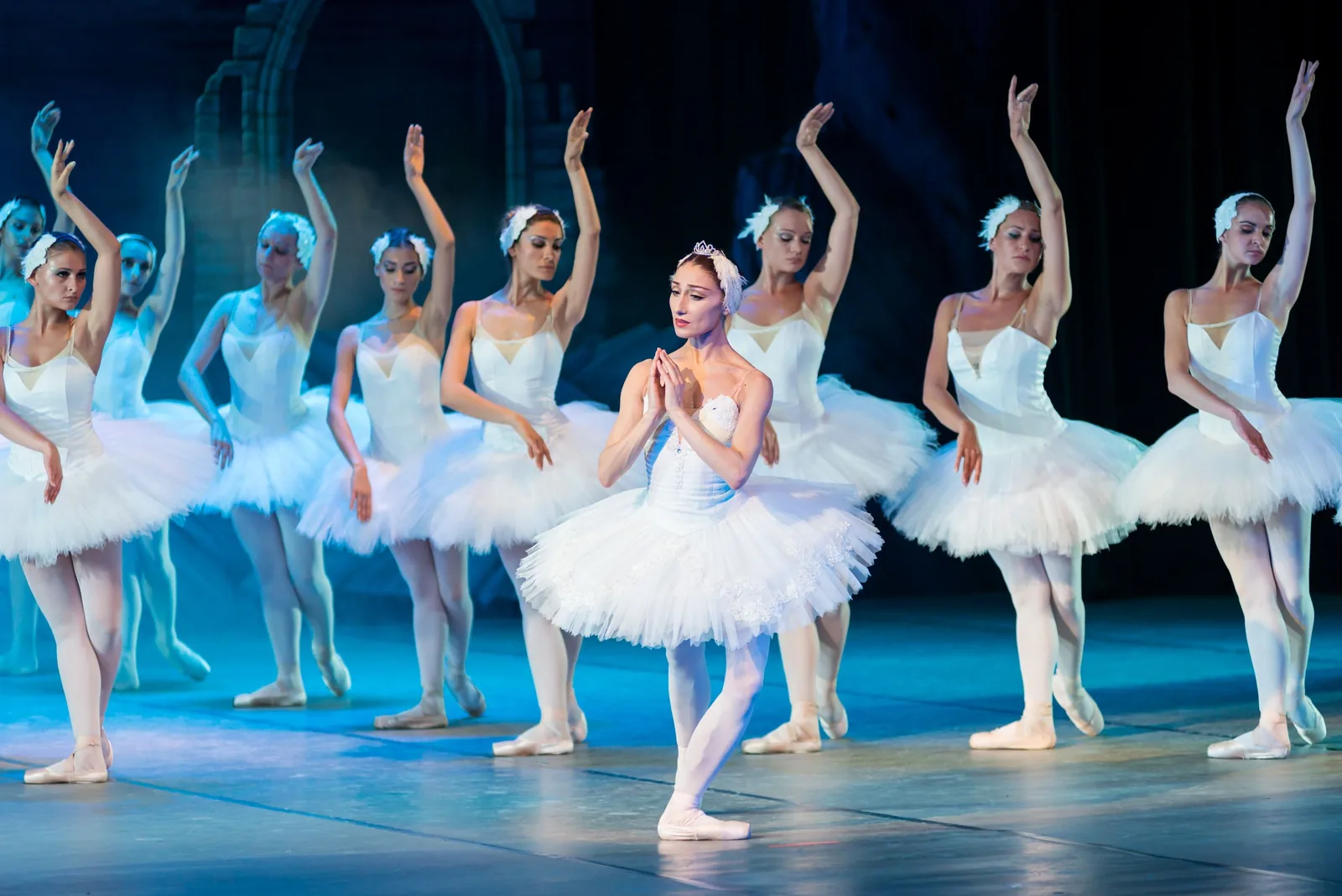 Dancers in white tutus on stage during a ballet performance
