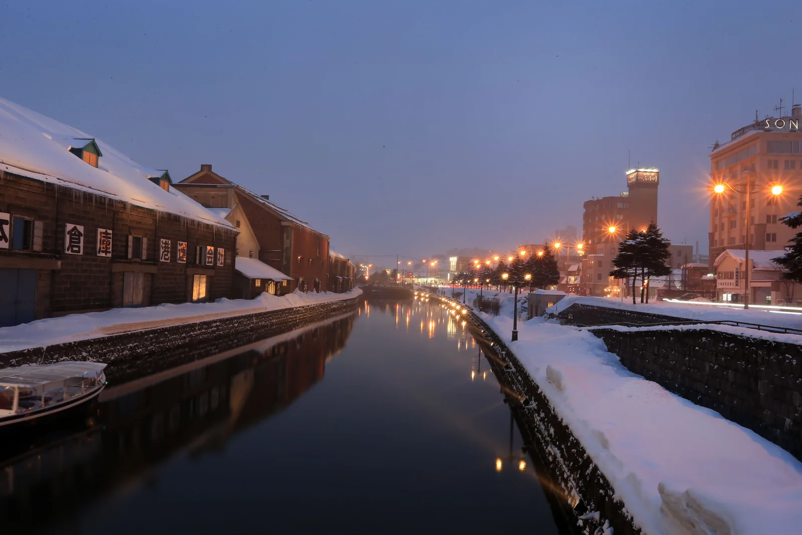 The Otaru canal and its stone warehouses lit at dusk in winter