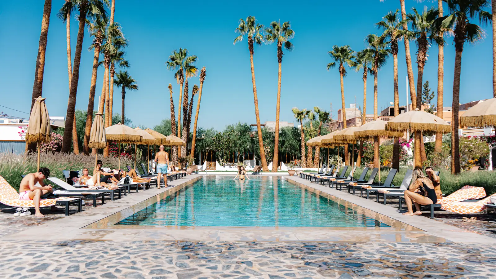 Loungers beside a palm lined swimming pool in Palm Springs, California