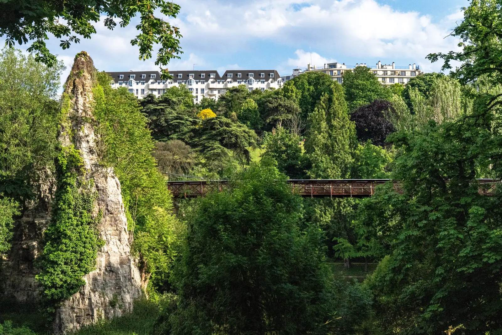 The rock outcrop and green slopes of Parc des Buttes Chaumont in Paris