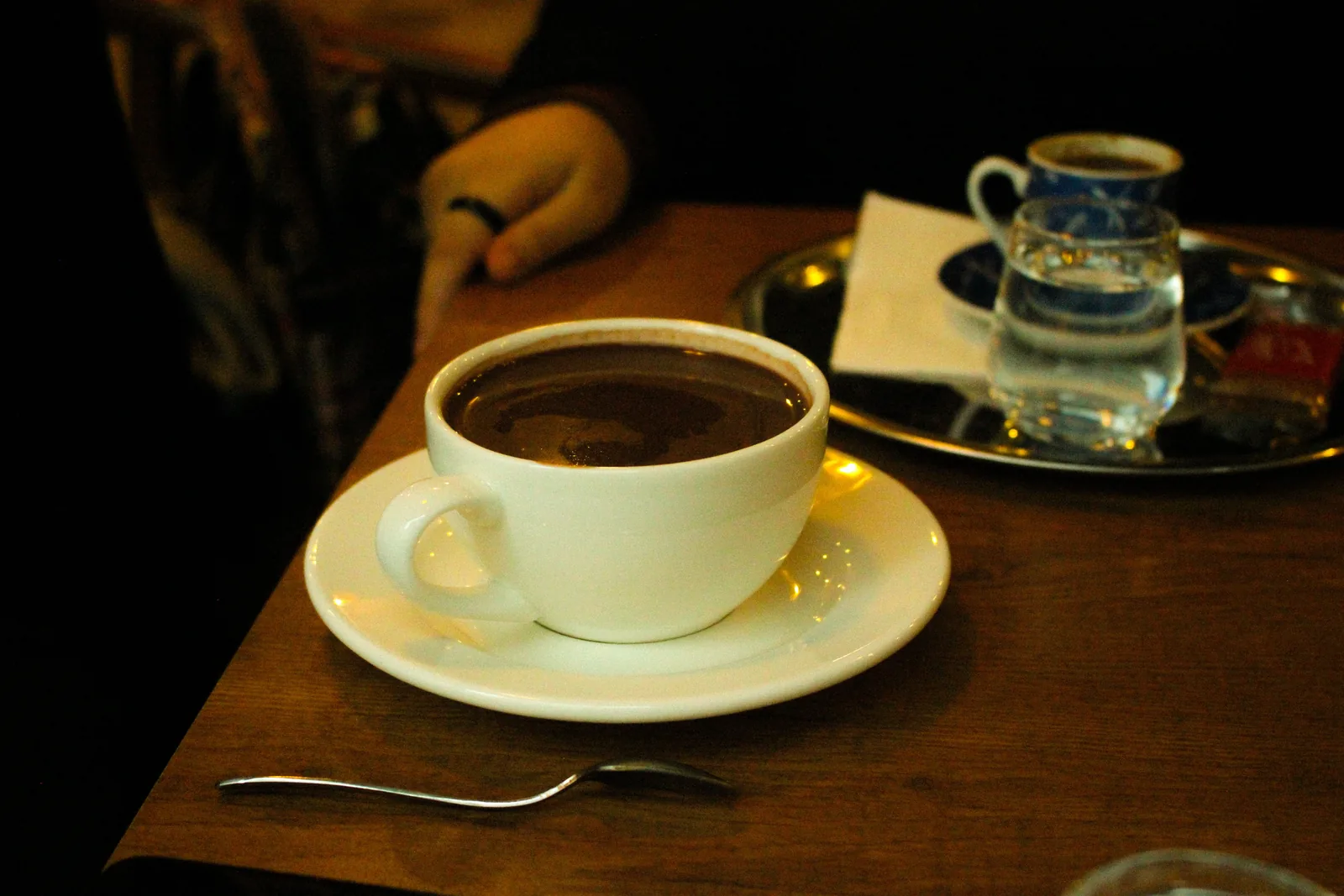 A cup of thick hot chocolate on a wooden cafe table