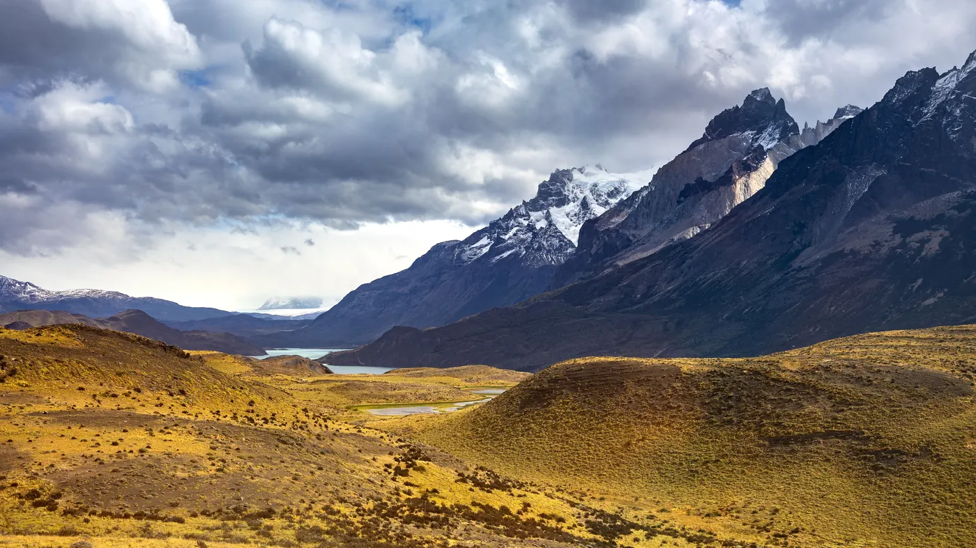 The peaks of Torres del Paine above golden grassland in Patagonia