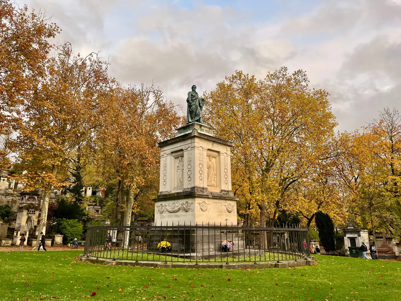 Autumn trees around a stone monument in Pere Lachaise cemetery in Paris
