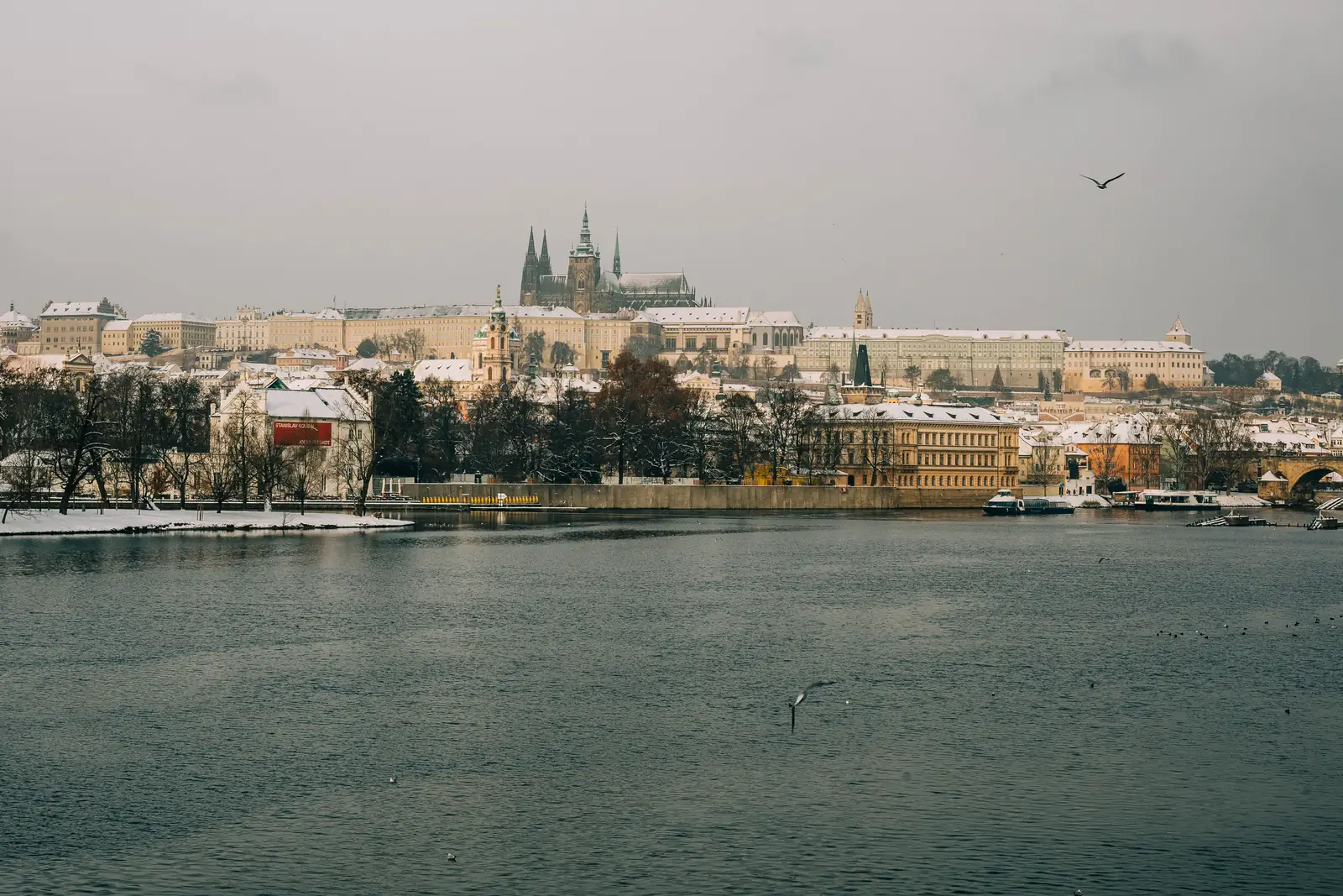 Prague Castle above the Vltava with snow on the rooftops