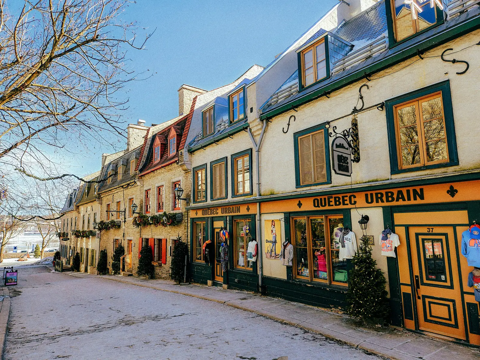 Snow banked up outside the shopfronts on a street in Old Quebec