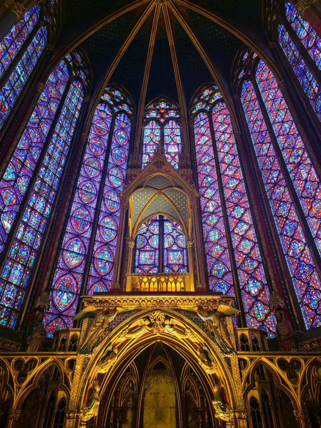 The stained glass windows of Sainte Chapelle in Paris rising two storeys around the upper chapel