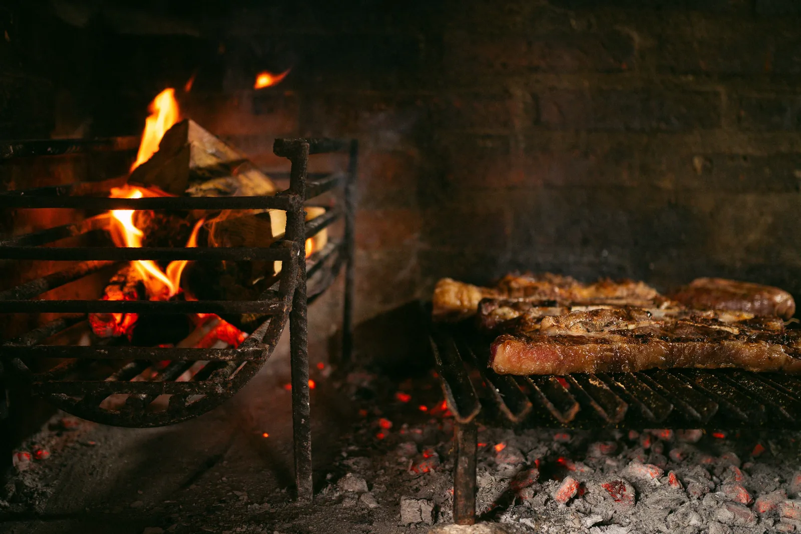 Meat cooking on a grate over an open fire pit