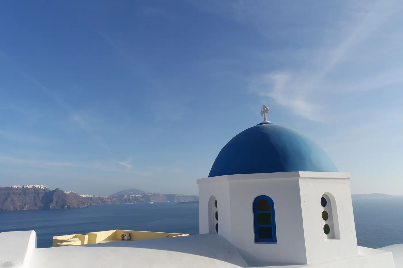 A blue domed church above the caldera on Santorini