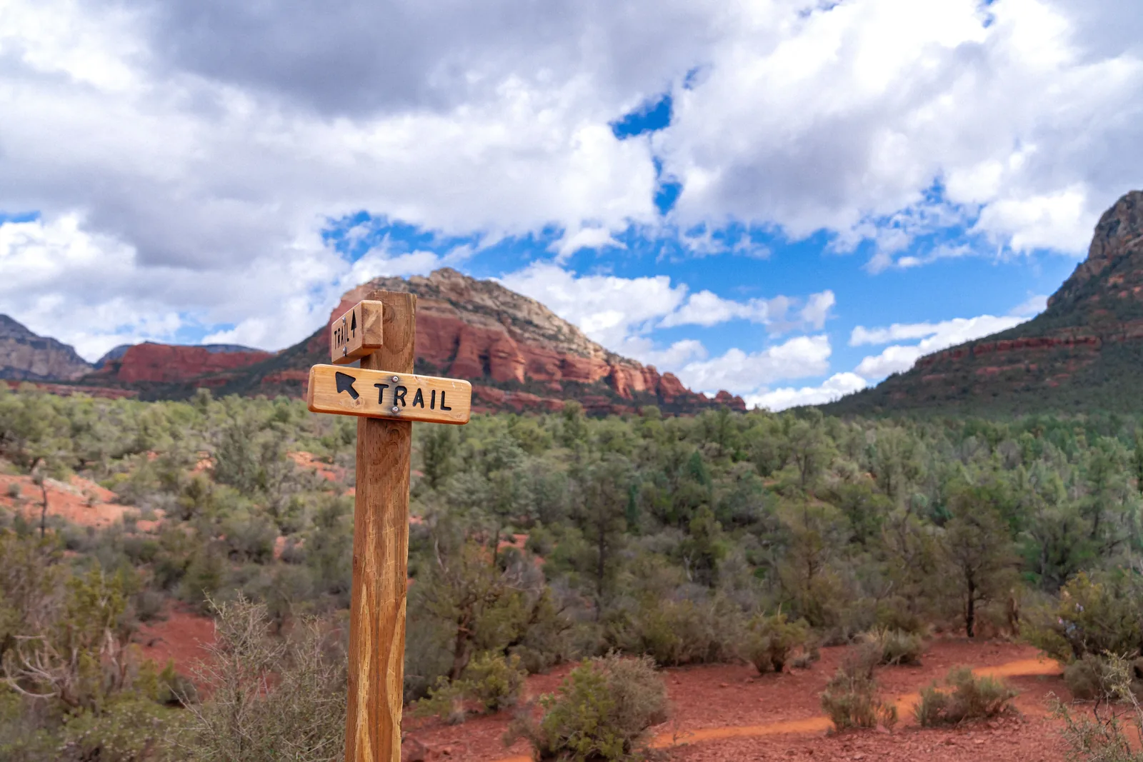 A wooden trail marker below the red rocks in Sedona Arizona