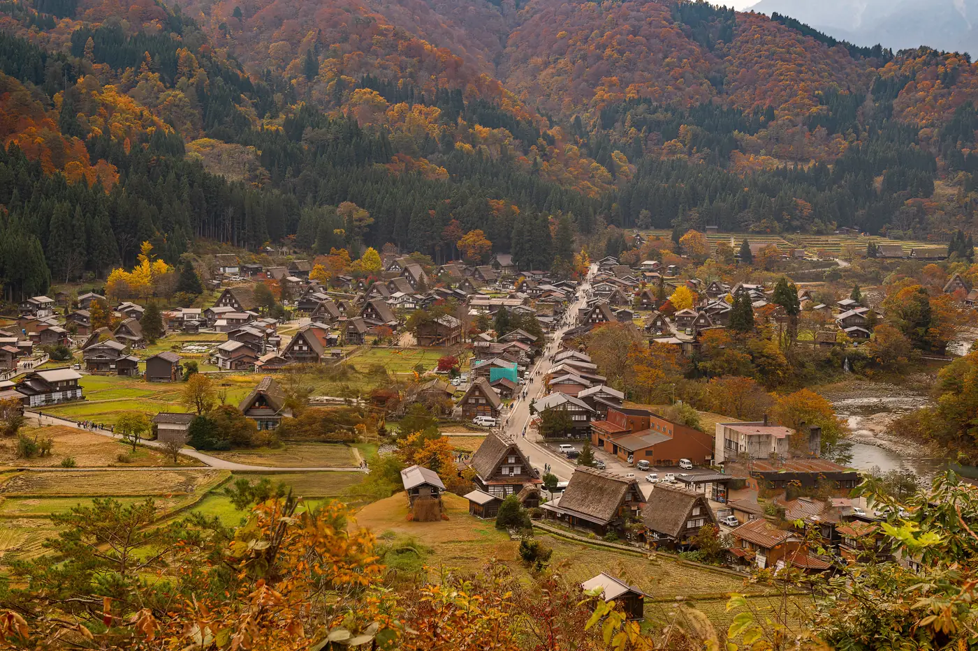 The thatched roofs of Shirakawa-go with autumn colour on the hills behind