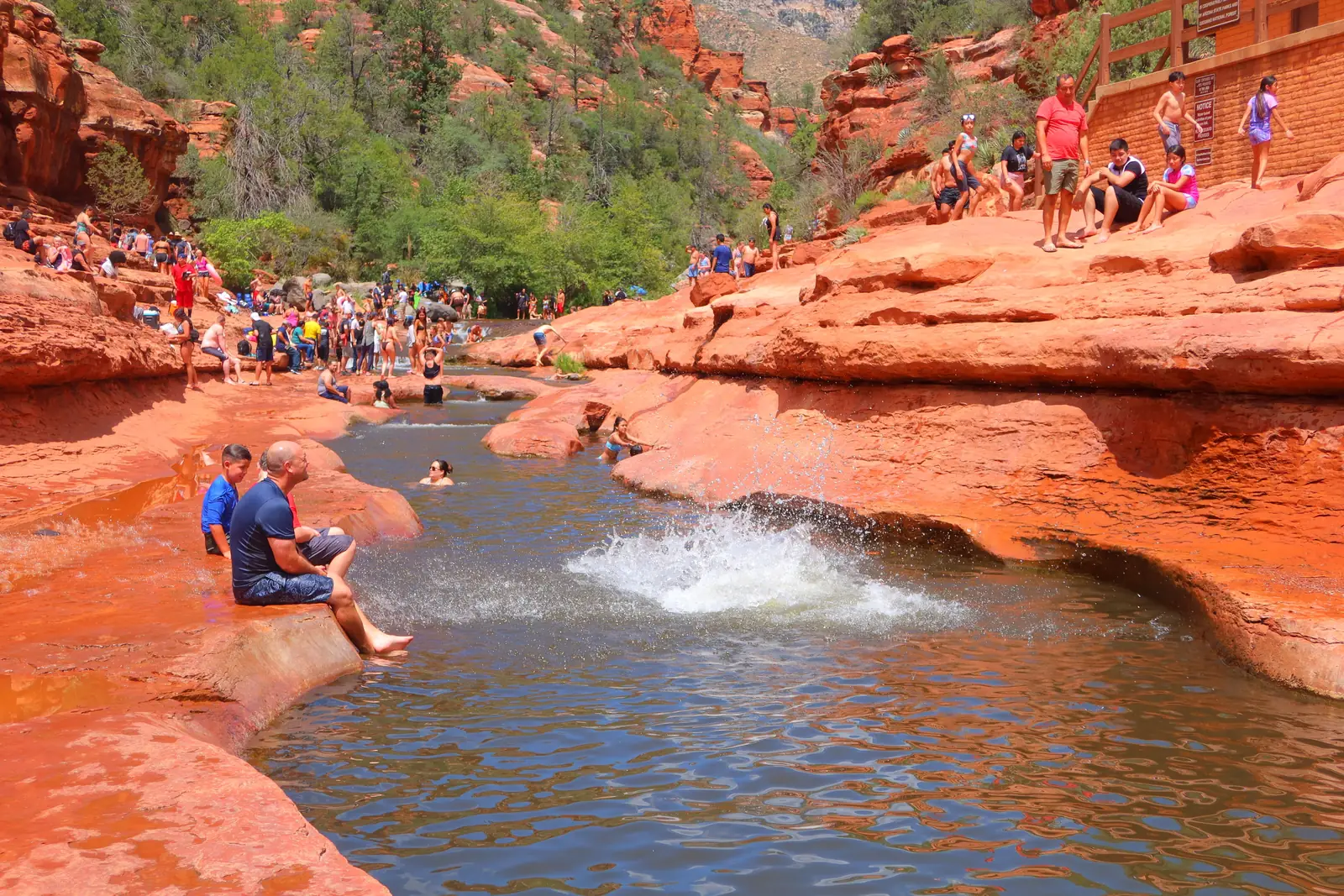 People sitting along the creek at Slide Rock State Park in Arizona