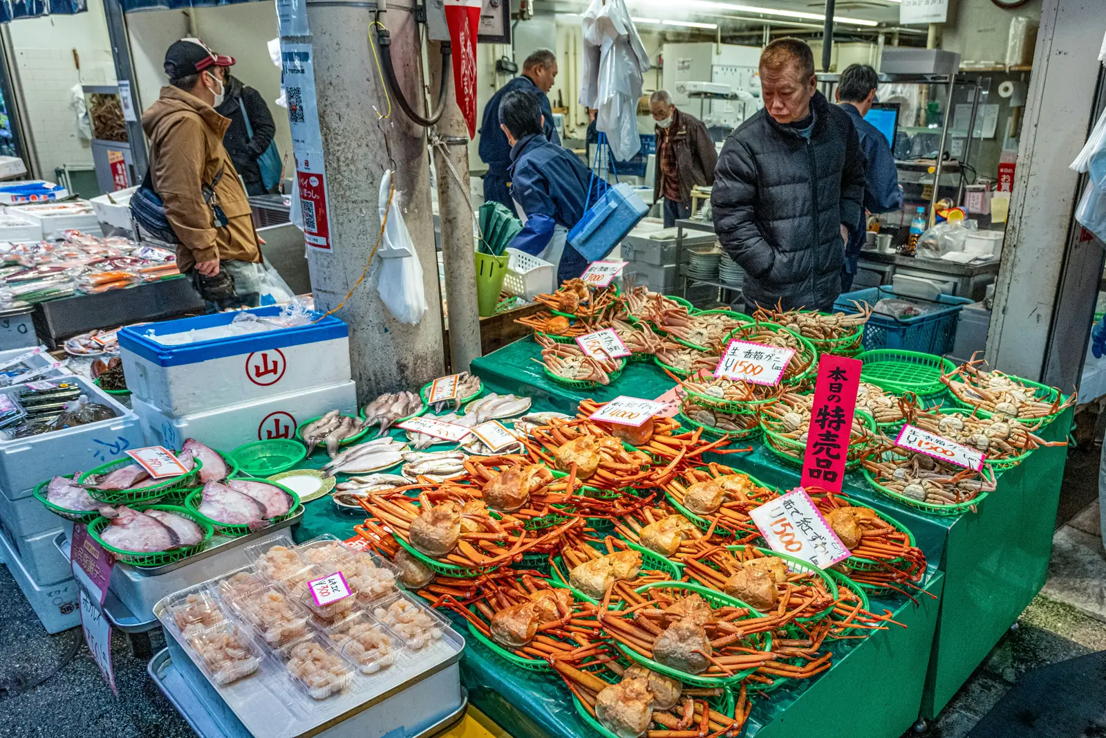 Crab and fresh fish laid out on ice at a Japanese market stall
