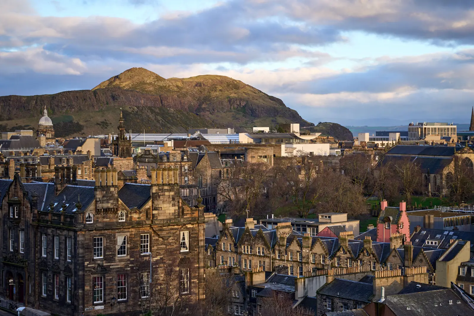 Edinburgh rooftops with the green slope of Arthur's Seat rising behind them