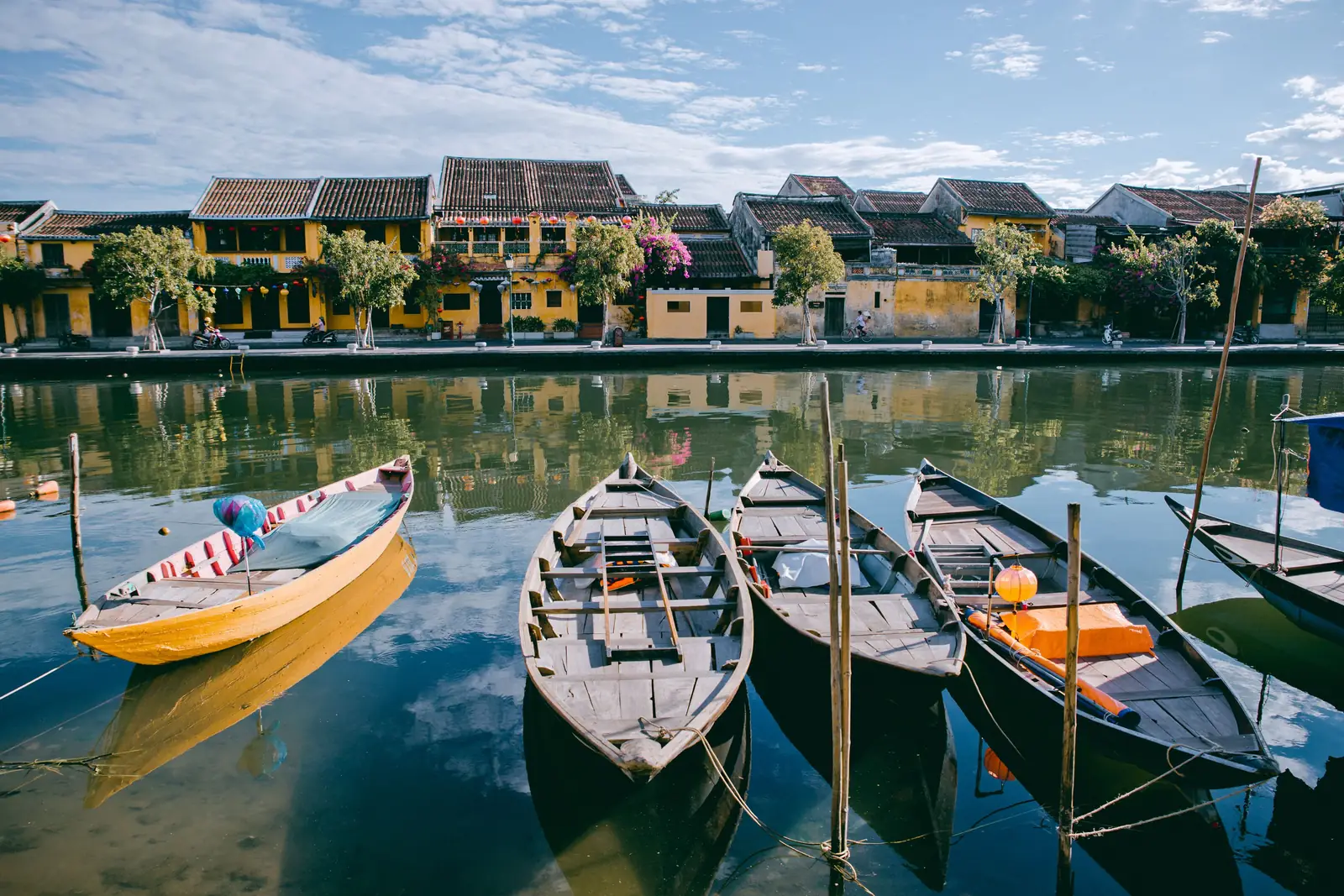 Wooden boats moored on the river in front of the old town in Hoi An