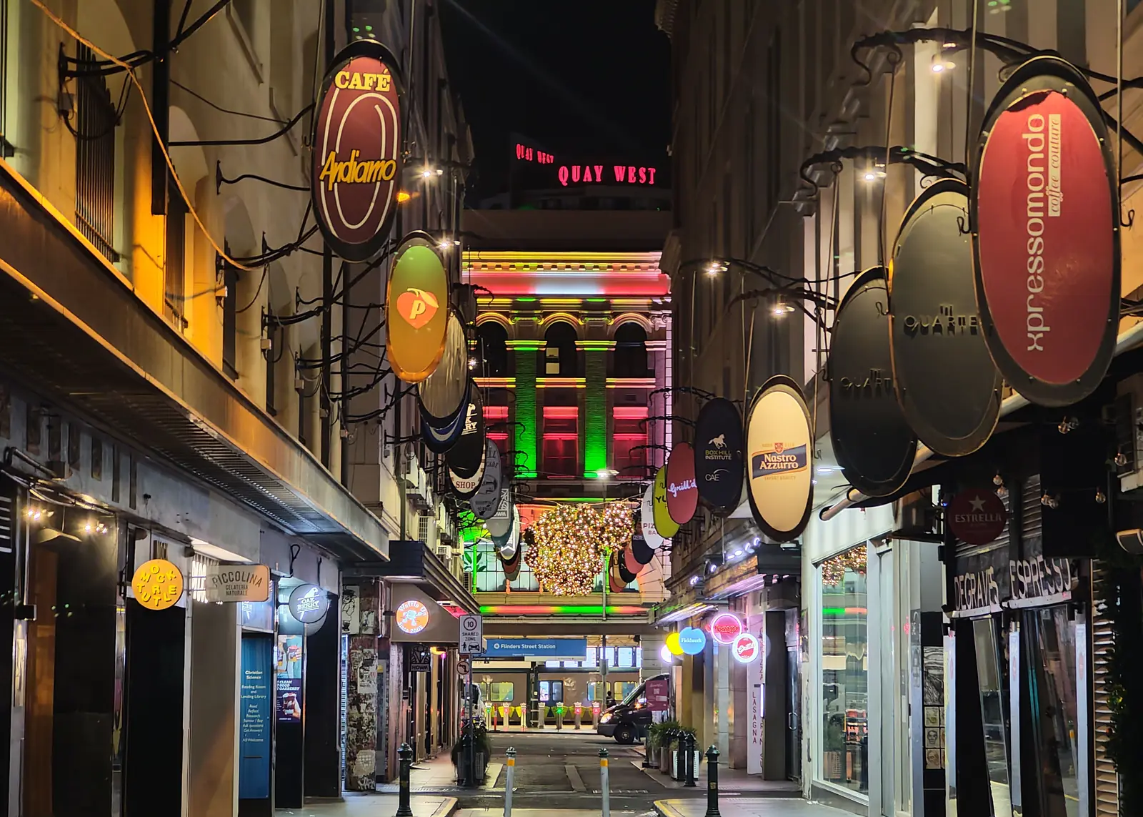 Neon cafe signs hanging along a narrow laneway in Melbourne