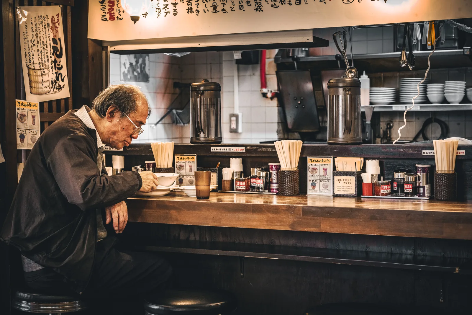 A customer eating alone at a ramen counter in Japan