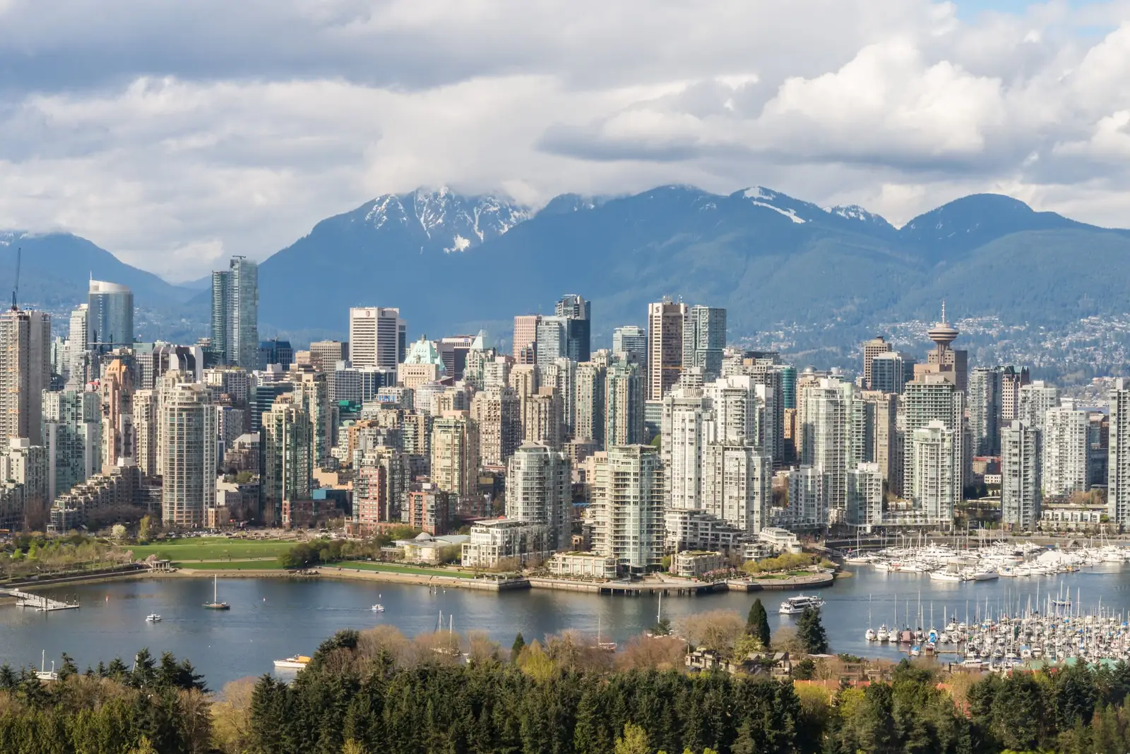 The Vancouver skyline with snow topped mountains rising behind the city