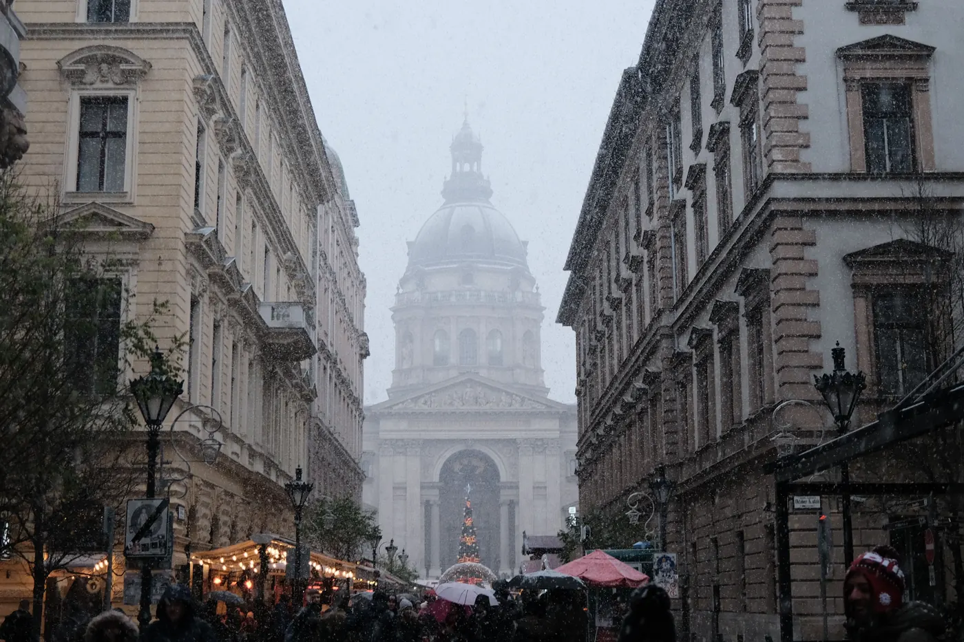 Snow falling over a Budapest street with the Christmas market and St. Stephen's Basilica ahead