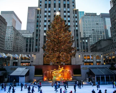 The Rockefeller Center Christmas tree lit above the ice rink with skaters below