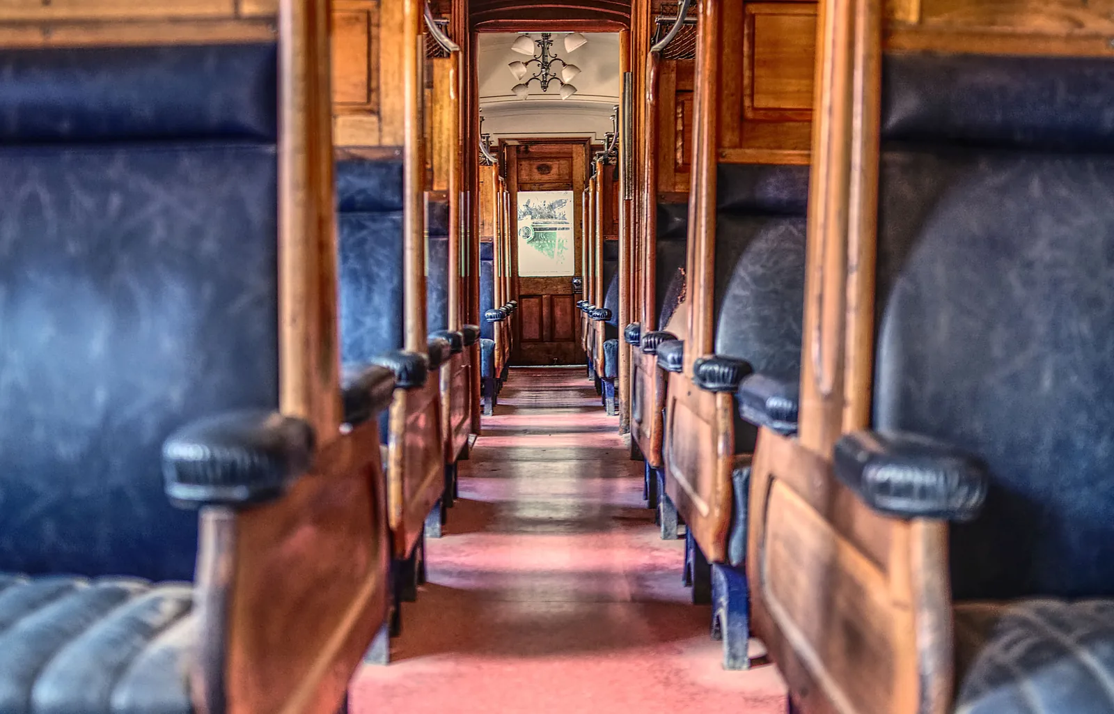 The wooden interior of a vintage train car with empty seats