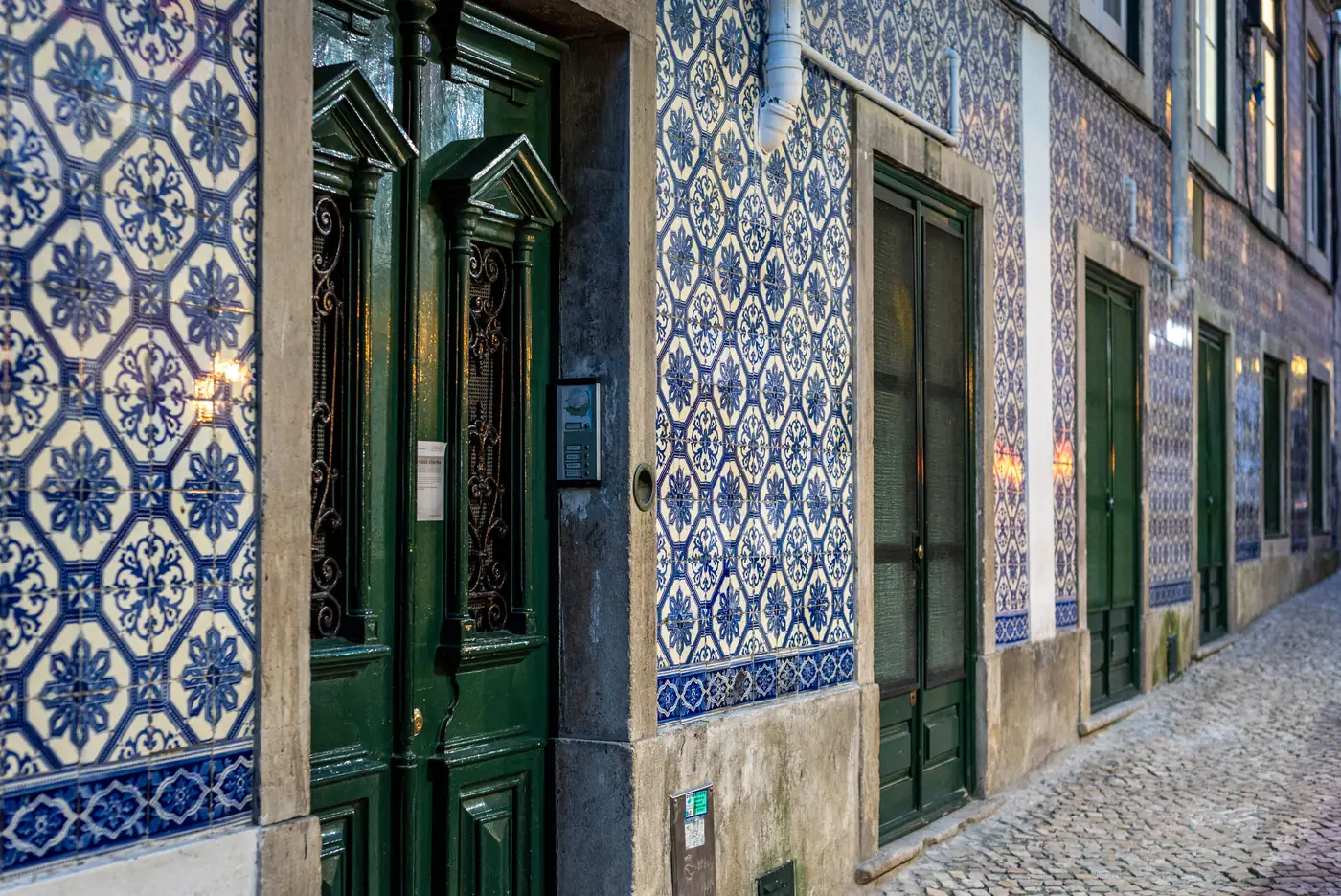 A cobbled Lisbon street lined with blue and white tiled buildings