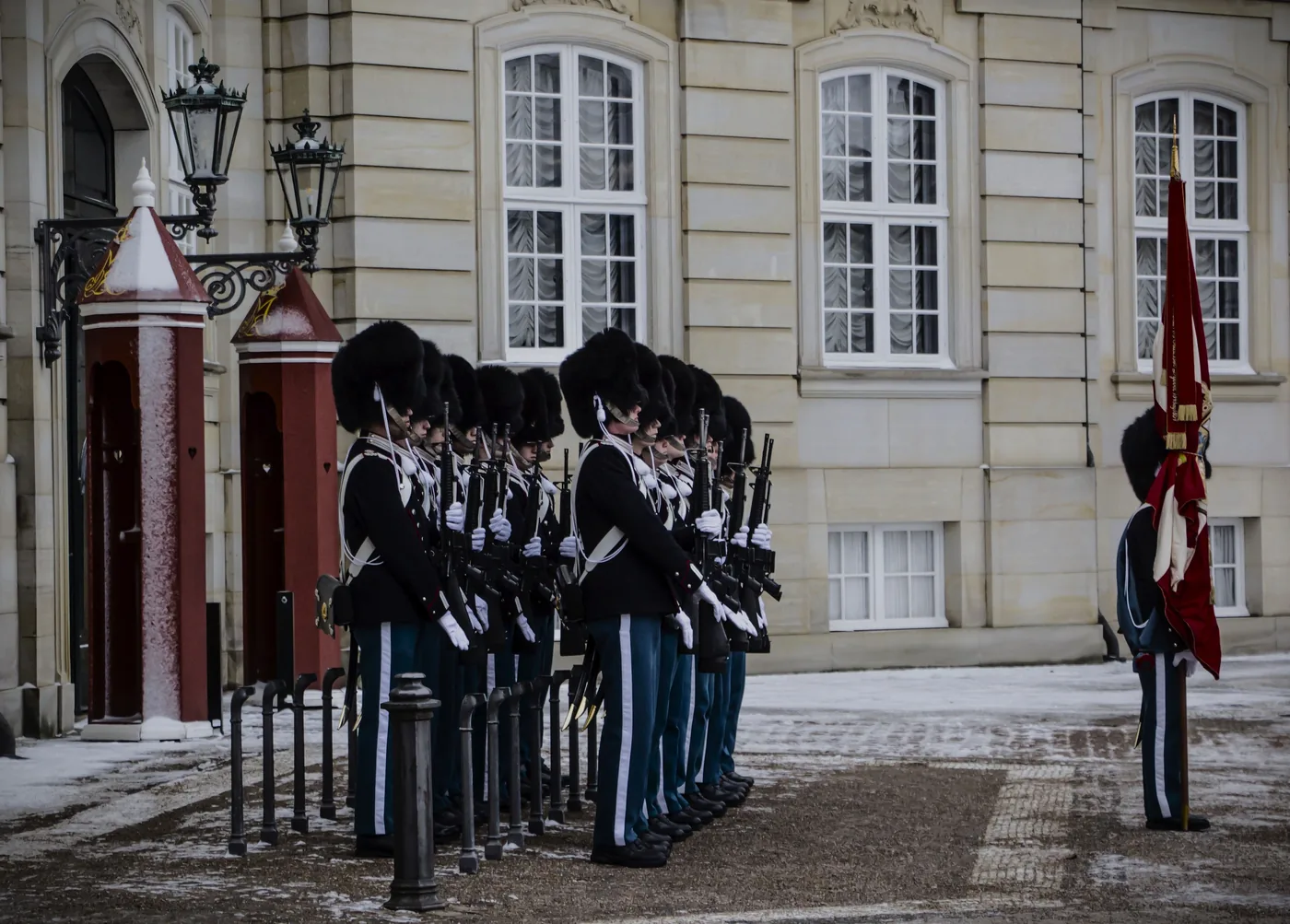 Royal guards in bearskin hats lined up at Amalienborg Palace in winter