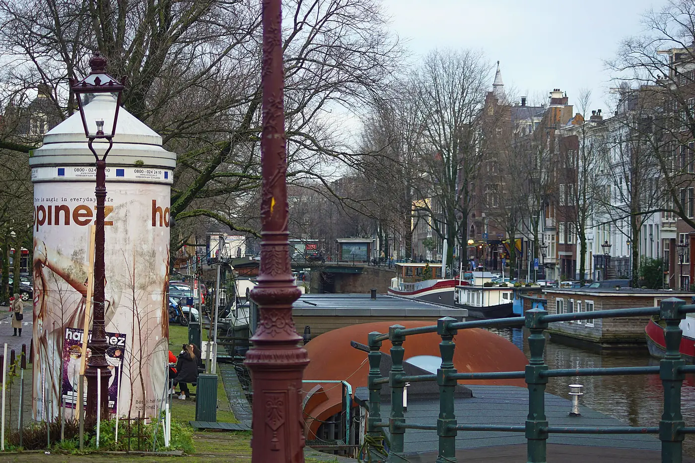 A leafy Amsterdam canal lined with houseboats