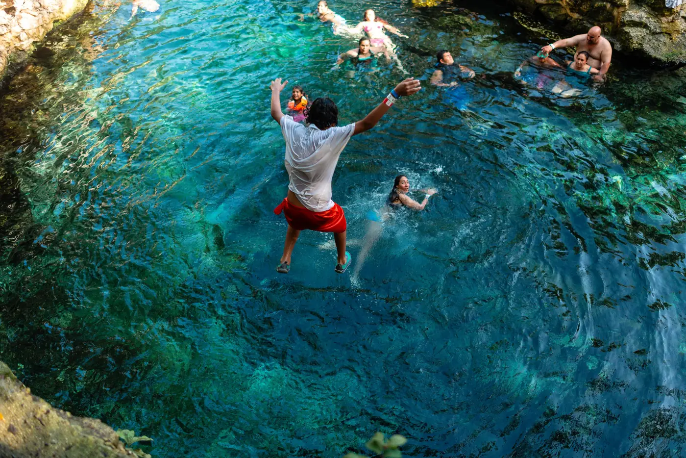 Swimmers jumping into a cenote near Tulum, Mexico